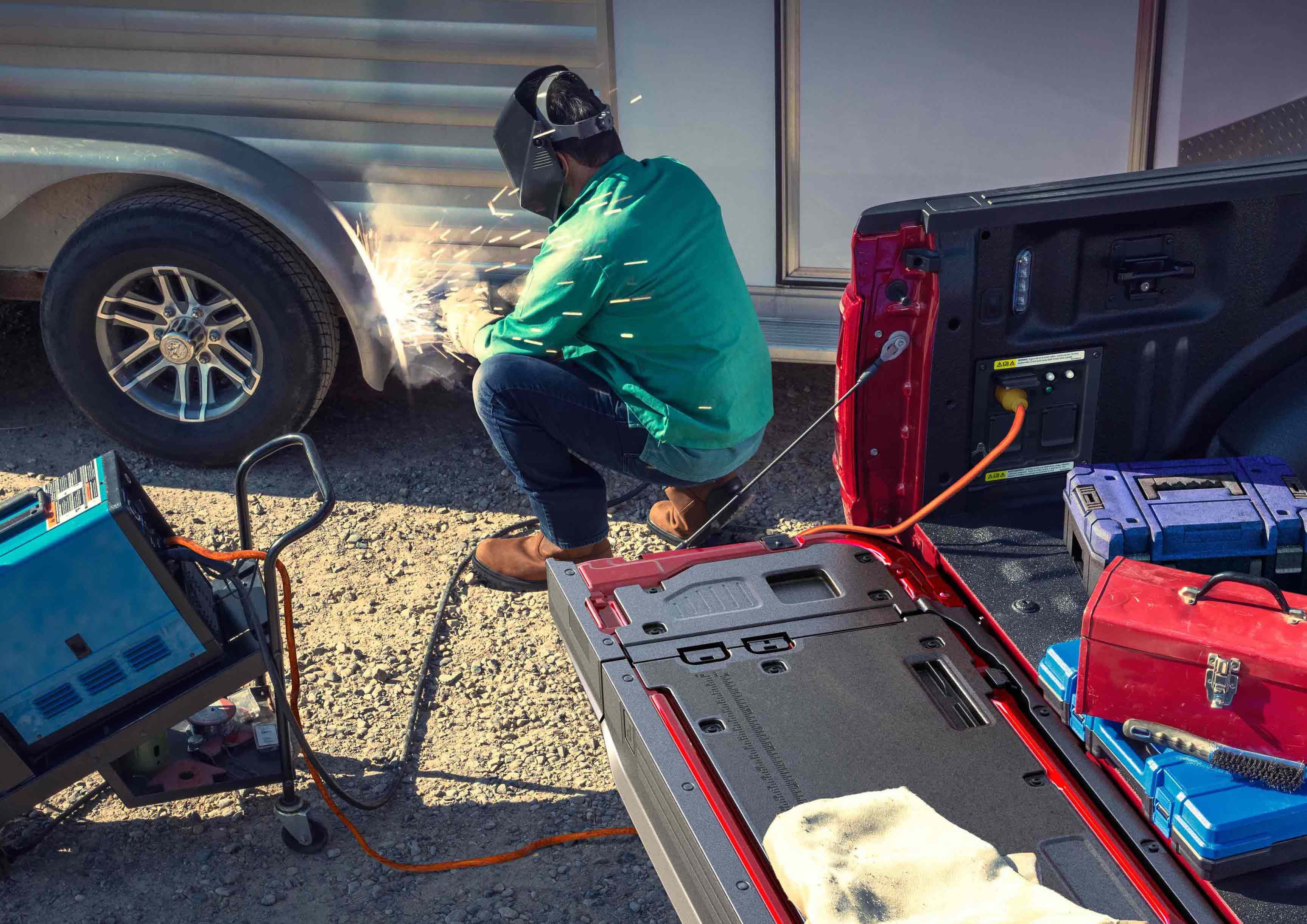 Person using a TIG welder that's plugged into the Pro Power Onboard feature located in the truck bed
